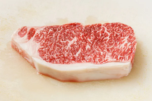 关闭神户牛肉 Striploin 牛排在肮脏的塑料切割板上 — 图库照片