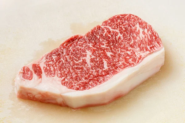 关闭神户牛肉 Striploin 牛排在肮脏的塑料切割板上 — 图库照片