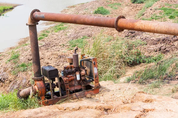Bomba vieja y oxidada con tubería de acero grande que bombea agua del lago —  Fotos de Stock