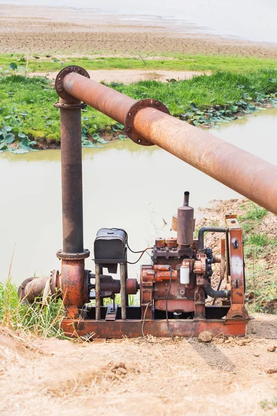 Pompe vieille et rouillée avec grand tuyau en acier pompage de l'eau du lac — Photo