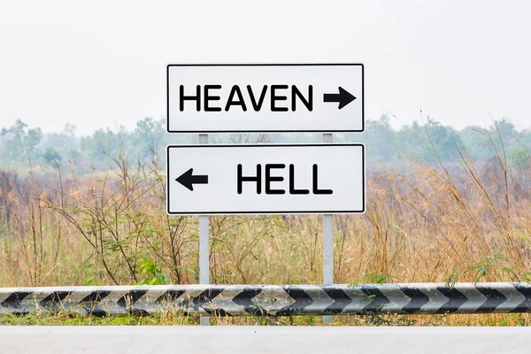 Road sign boards with heaven and hell text