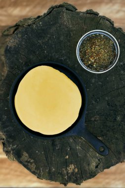 Lezzetli Arjantin Provolone İplik Peyniri (Provoleta), Arjantin 'in Buenos Aires şehrinde ahşap bir yüzey üzerinde eski bir kütük parçalarıyla birlikte. Açık hava sahnesi. Barbekü arkaplanı. 