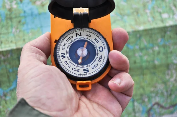 The compass in his hand outdoors. — Stock Photo, Image