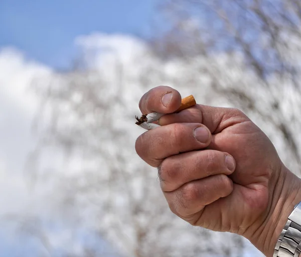 Un cigarrillo roto en su mano. — Foto de Stock
