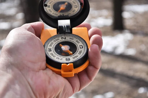 The compass in his hand outdoors. — Stock Photo, Image