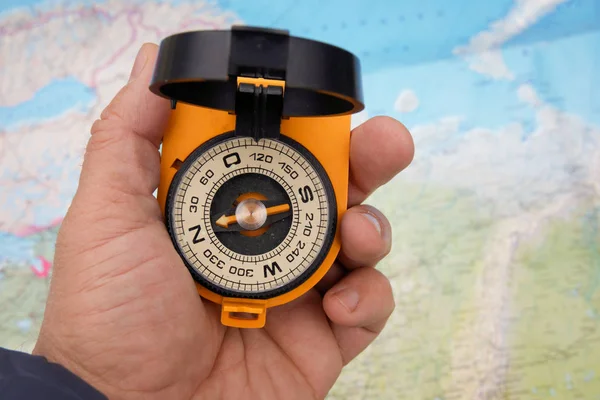 Compass in hand on a map background. — 스톡 사진