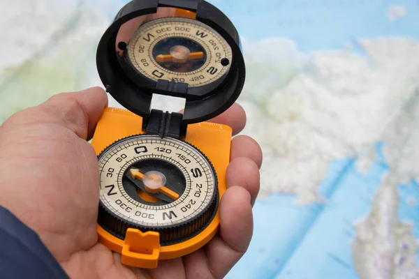 Kompass i handen på karta bakgrund. — Stockfoto