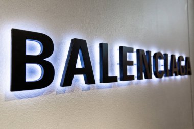 LONDON, UK - FEBRUARY 20, 2020: Balenciaga backlit logo in Harrods shopping mall. Balenciaga is a luxury fashion house founded in Spain by Cristobal Balenciaga.