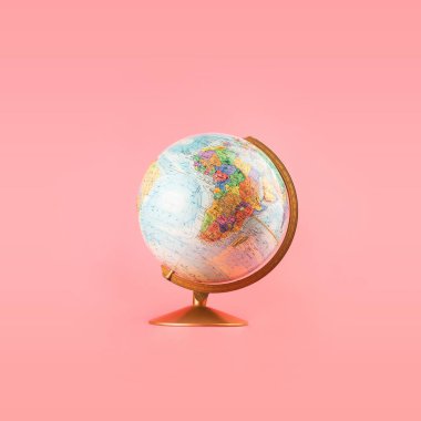 Minimum pastel pembe arka planda izole edilmiş dünya modeli. Basit moda cazibe seyahat konsepti. Kopya için boşluk, metin için oda.