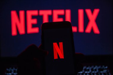 TERNOPIL, UKRAINE - JANUARY 11, 2020: Red Netflix brand logo on black screen of iPhone 7 in the evening. Netflix is a global video streaming service.