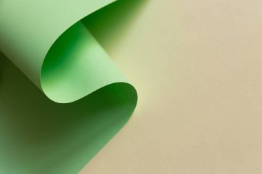 Açık yeşil kağıdın doğal sarı düz arkaplan üzerindeki soyut tasarımı. Moda trend neo nane rengi rulosu.