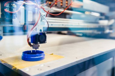 3D yazıcı platformunda taze basılmış mavi plastik detay