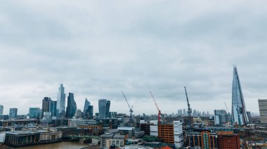 Londra kışı, gökdelenler ve vinçlerle dolu panoramik gökyüzü bulutlu bir günde. Sıkıcı bulutlu bir gün. Kopya için boşluk, metin için oda.
