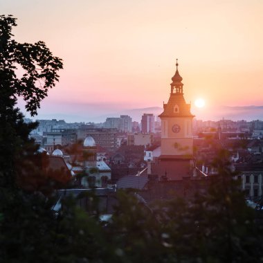 Kasaba meclisi binası kulesi sabah güneşinin doğuşu manzaralı Brasov şehri, Transilvanya, Romanya. Meşhur seyahat yeri manzaralı yaz renkli kartpostal.