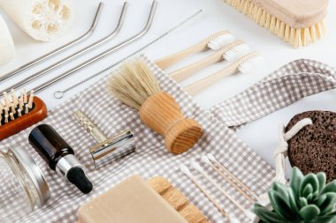 Çevre dostu banyo ve mutfak aksesuarları sade beyaz masa arkasına yerleştirilmiş. Sürdürülebilir yaratıcı yaşam tarzı konsepti. Basit bileşim izometrik görünümünü temizle.