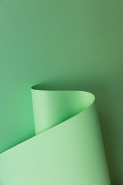 Açık yeşil eğrinin soyut yaratıcı tasarımı düz arkaplanda kağıt şeklinde. Tek renkli geometrik moda posteri. Kopyalama, metin ve harf için boş boşluk.