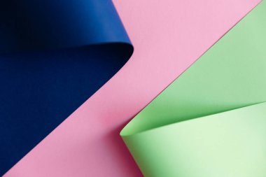 Bükülmüş koyu lacivert ve açık yeşil (neo naneli) renkler Pastel pembe arka planda trend oluyor. Soyut kağıt moda arka plan tasarımı.