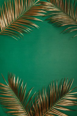 Zümrüt yeşili zümrüt yeşili arka planda duran altın renkli parlak hurma yaprakları. Tropik lüks şık düğün davetiyesi şablonu. Boş alan, metin için yer, kopyala.