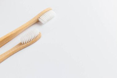 Beyaz arka planda iki bambu diş fırçası izole edilmiş. Boş alan, mesaj için yer. Çevre dostu, sıfır atık, plastik içermeyen konsept.