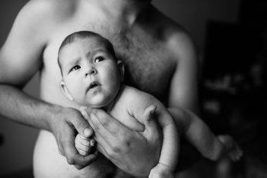 Babasının güçlü ve şefkatli ellerinde tutulan küçük tatlı bir kızın siyah beyaz portresi..