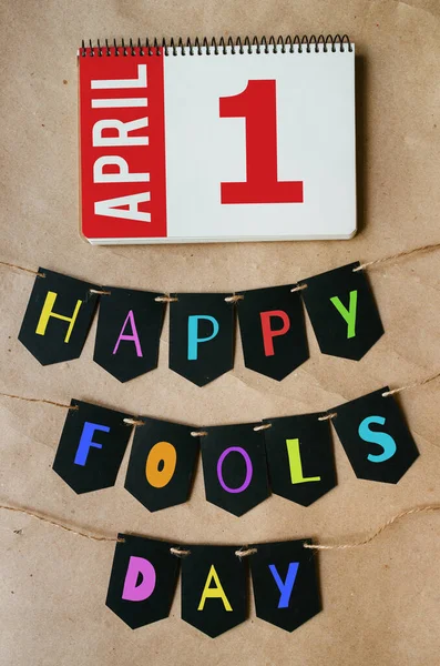 Happy april fools day banner lettering on craft paper background. Calendar page April, 1. Greeting postcard template.