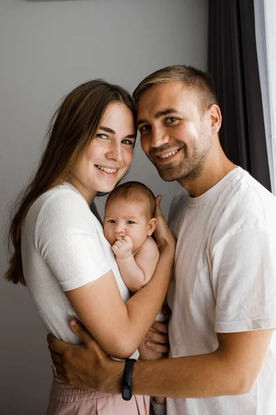 Jóvenes Padres Felices Abrazando Sosteniendo Pequeña Niña Sonriendo Mirando Directamente — Foto de Stock