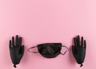 Siyah lateks eldivenler ve pembe arka planda yüz maskesi. Mesaj için yer var. Coronavirus moda kavramından korunma.