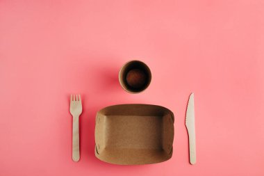 Pastel pembe arka planda biyolojik olarak bozunabilir mutfak gereçleri..