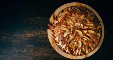 Doğal ev yapımı elmalı turtanın en üst görüntüsü. Koyu kırsal ahşap masa ve fotokopi alanı olmadan. Tarif düzlüğü.