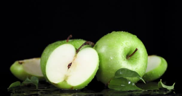 Otáčení čerstvých zelených jablek s kapkami vody.