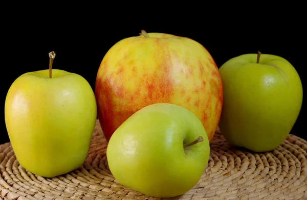 Три зеленых и одно большое яблоко — стоковое фото