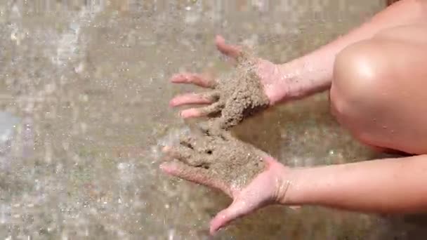 Sand i havet på deres hænder – Stock-video