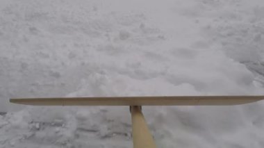 Şehirdeki bir konutta kaldırımdan kar temizliyorum.