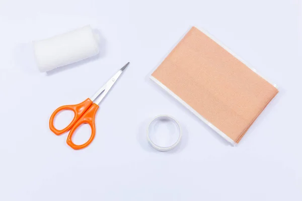 Items from a home medical kit including plaster, bandage and tape