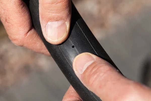 Person holding an inner tube of a bicycle showing puncture hole