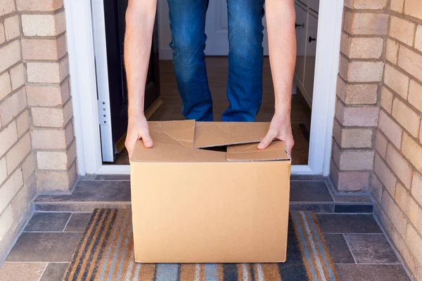 Person receiving a home delivery at a front doorstep
