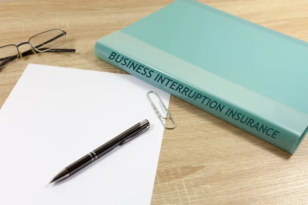 Business Interruption Concept - Folder and paper on desk - folder reads 'Business Interruption Insurance'