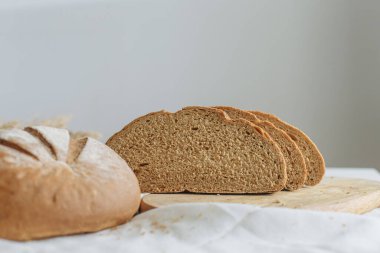 Beyaz bir masa örtüsünün üzerinde dilimlenmiş ekmek.