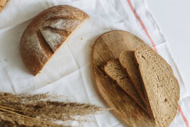 Beyaz bir masa örtüsünün üzerinde dilimlenmiş ekmek.
