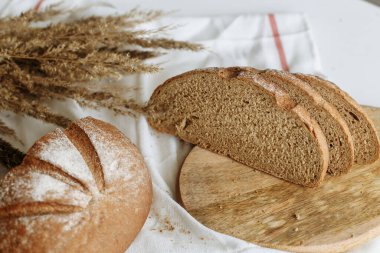 Beyaz bir masa örtüsünün üzerinde dilimlenmiş ekmek.