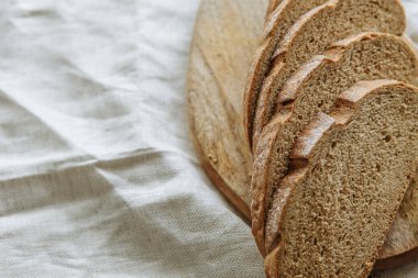 Beyaz bir masa örtüsünün üzerinde dilimlenmiş ekmek.