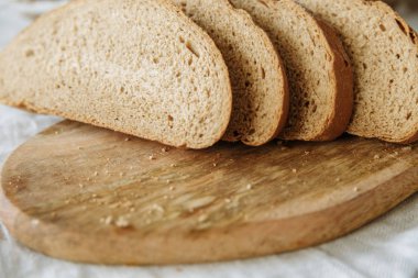 Beyaz bir masa örtüsünün üzerinde dilimlenmiş ekmek.