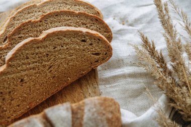 Beyaz bir masa örtüsünün üzerinde dilimlenmiş ekmek.