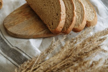 Beyaz bir masa örtüsünün üzerinde dilimlenmiş ekmek.