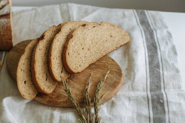 Beyaz bir masa örtüsünün üzerinde dilimlenmiş ekmek.
