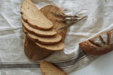 Beyaz bir masa örtüsünün üzerinde dilimlenmiş ekmek.