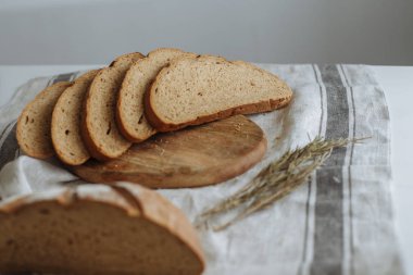 Beyaz bir masa örtüsünün üzerinde dilimlenmiş ekmek.