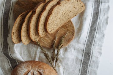 Beyaz bir masa örtüsünün üzerinde dilimlenmiş ekmek.
