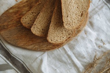 Beyaz bir masa örtüsünün üzerinde dilimlenmiş ekmek.