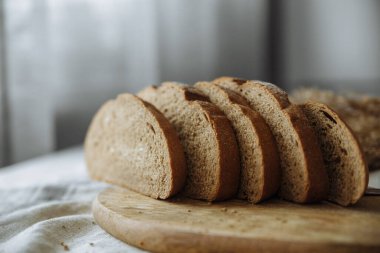 Beyaz bir masa örtüsünün üzerinde dilimlenmiş ekmek.